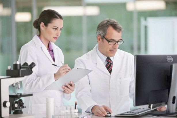 Two people doing reseach work on computer in laboratory with Dell U2412M monitor.