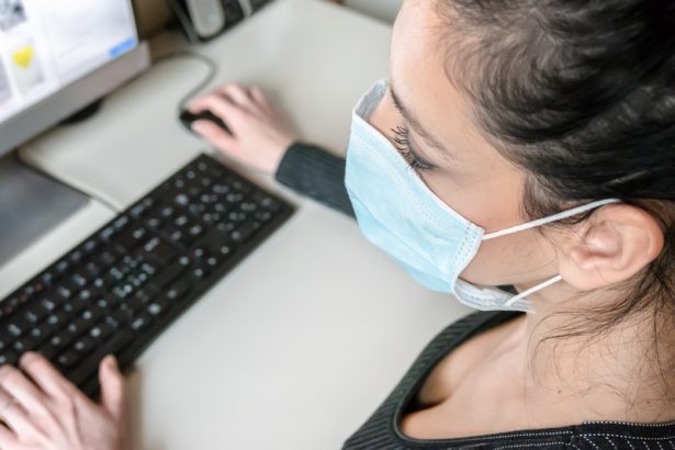 Business woman working from home wearing protective mask